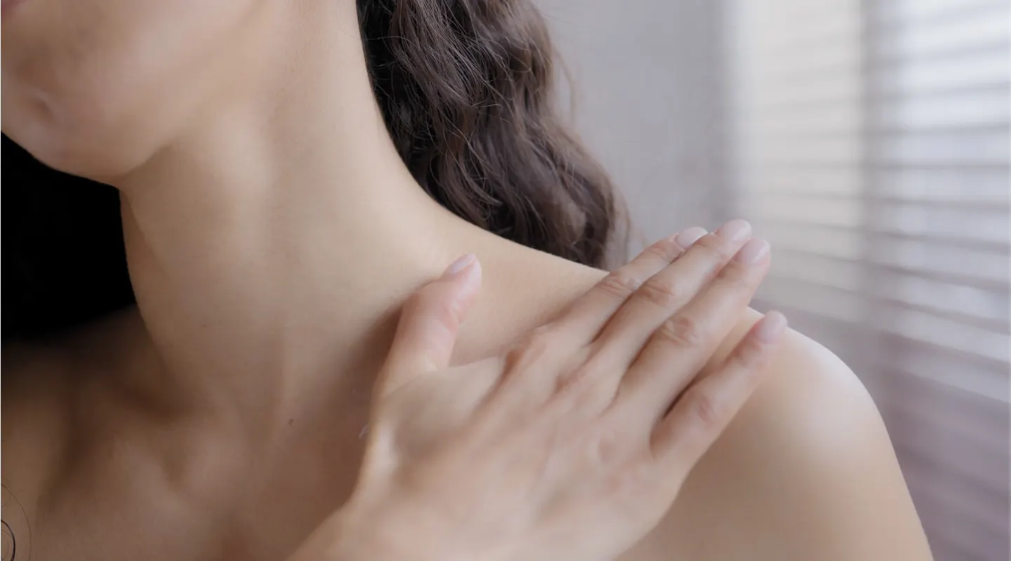A hand resting on a bare shoulder